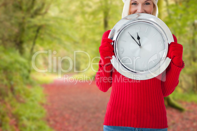 Composite image of happy festive blonde with clock