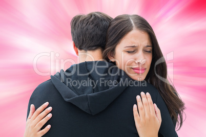 Composite image of unhappy brunette hugging her boyfriend