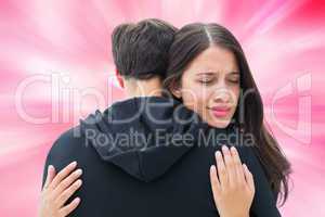 Composite image of unhappy brunette hugging her boyfriend