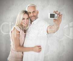 Composite image of happy couple posing for a selfie