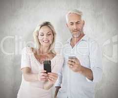 Composite image of happy couple texting on their smartphones