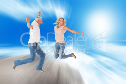 Composite image of excited couple cheering and jumping