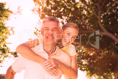 Happy senior man giving his partner a piggy back