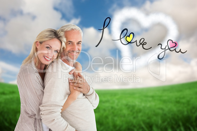 Composite image of happy couple standing and hugging