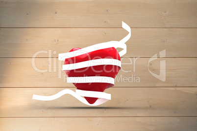 Composite image of love heart wrapped in ribbon