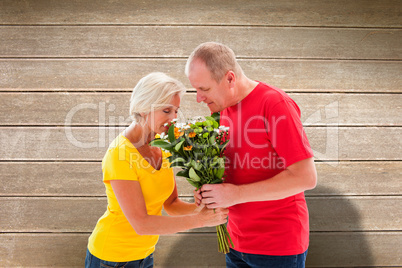 Composite image of mature man offering his partner flowers