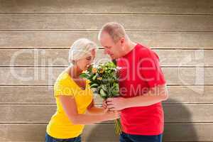 Composite image of mature man offering his partner flowers