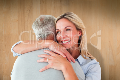 Composite image of happy couple standing and hugging