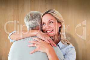 Composite image of happy couple standing and hugging