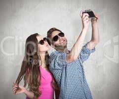 Composite image of couple taking selfie with digital camera