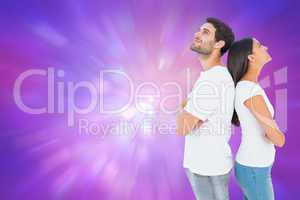 Composite image of happy couple standing looking up