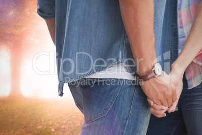 Composite image of hip young couple holding hands