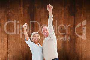 Composite image of happy mature couple cheering at camera