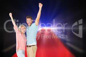Composite image of attractive couple smiling and cheering