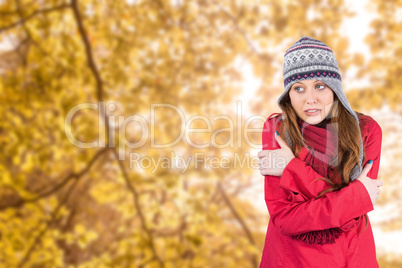 Composite image of cold redhead wearing coat and hat