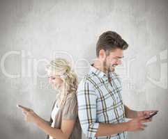 Composite image of attractive couple using their smartphones