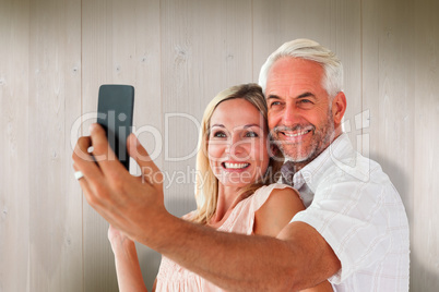 Composite image of happy couple posing for a selfie