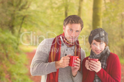 Composite image of couple both having warm drinks