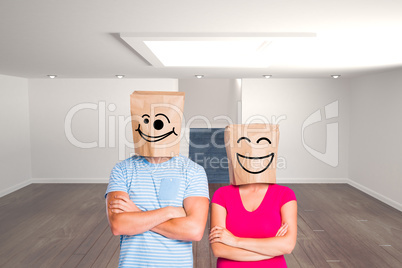 Composite image of young couple with bags over heads