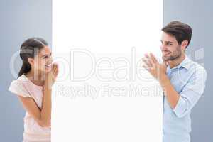 Composite image of attractive young couple smiling and holding p