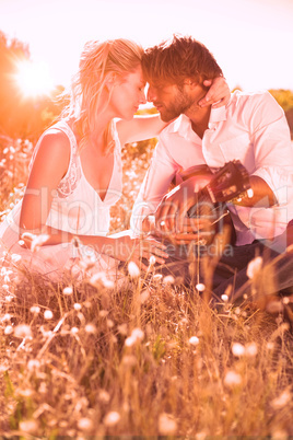 Handsome man serenading his girlfriend with guitar