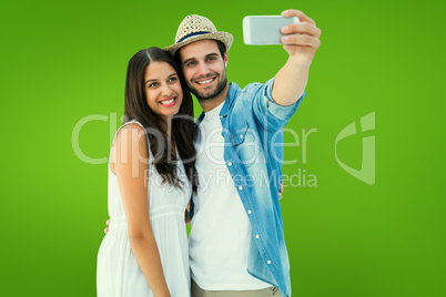 Composite image of happy hipster couple taking a selfie