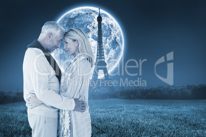 Composite image of happy couple standing and hugging