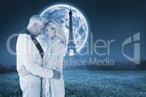 Composite image of happy couple standing and hugging