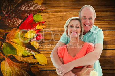 Composite image of happy older couple holding paint roller