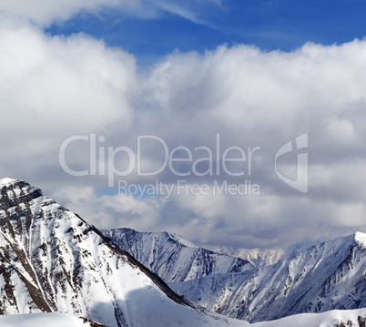 Winter snowy mountains in clouds at nice day