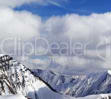 Winter snowy mountains in clouds at nice day