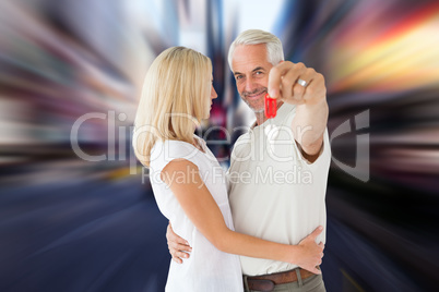 Composite image of happy couple showing their new house key