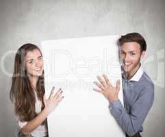 Composite image of happy young couple with blank board