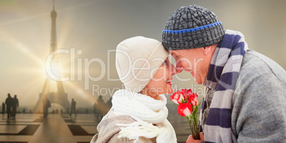 Composite image of happy mature couple in winter clothes with ro