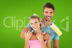 Composite image of young couple hugging and holding paint roller