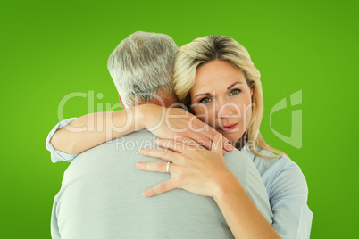 Composite image of unhappy blonde hugging her husband