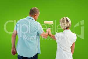 Composite image of happy older couple painting white wall