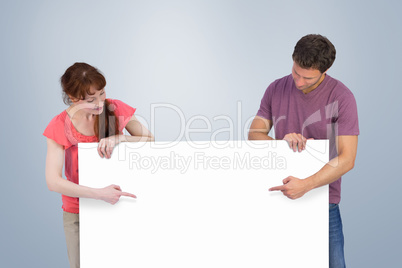 Composite image of couple looking at a sign