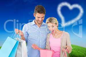 Composite image of attractive young couple holding shopping bags