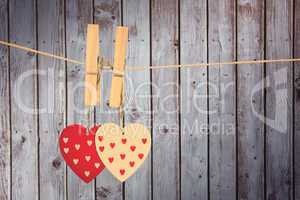 Composite image of hearts hanging on the line