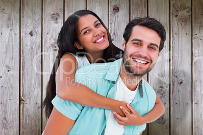 Composite image of happy casual man giving pretty girlfriend pig