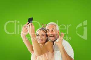 Composite image of happy couple posing for a selfie