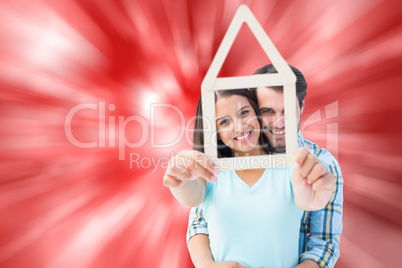 Composite image of happy young couple with house shape