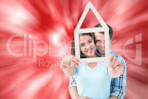 Composite image of happy young couple with house shape