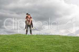 Composite image of man giving girlfriend piggy back