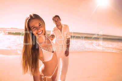Woman smiling at camera with boyfriend holding her hand