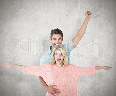 Composite image of attractive couple smiling and cheering