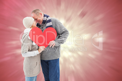 Composite image of happy mature couple in winter clothes holding