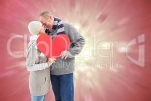 Composite image of happy mature couple in winter clothes holding