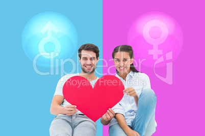 Composite image of cute couple sitting holding red heart